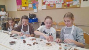 Uczennice przygotowują czekoladki na warsztatach czekoladowych
