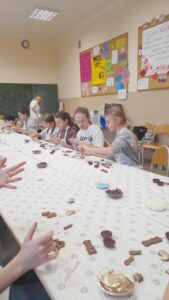 Uczennice przygotowują czekoladki na warsztatach czekoladowych