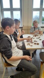 Uczniowie przygotowują czekoladki na warsztatach czekoladowych