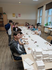 Grupa uczniów bierze udział w warsztatach czekoladowych.