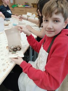Uczeń prezentuje swoją pracę na warsztatach czekoladowych.
