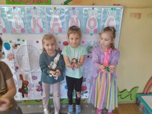 Trzy dziewczynki z przedszkola prezentują swoje wielkanocne prace plastyczne