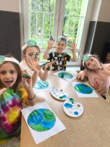 Grupa dzieci przygotowuje prace plastyczne na Światowy Dzień Ziemi