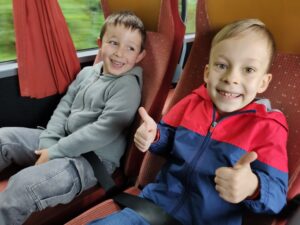 Dwóch uśmiechniętych chłopców pozuje do zdjęcia w autobusie