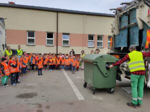 Uczniowie z wizyta w ZUK, uczą się o sortowaniu odpadów.
