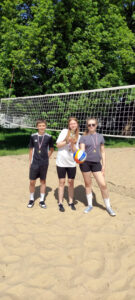 Grupa uczniów biorących udział w turnieju siatkówki plażowej